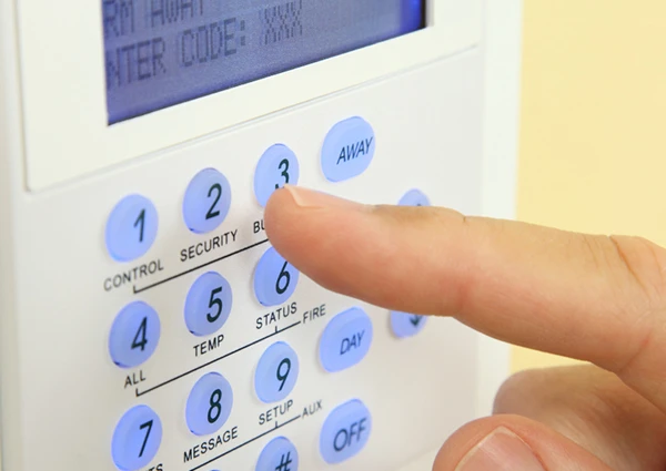 Person entering a security code on a digital keypad for a reliable burglar alarm system in Palm Beach Gardens, FL.