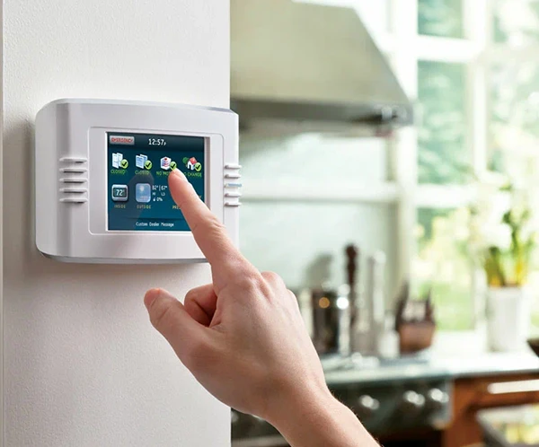 Person using a touchscreen security alarm control panel in a modern home, highlighting trusted electrical and security system experts in Palm Beach Island, FL.