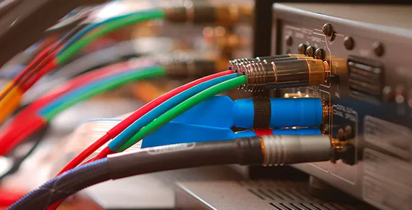 Close-up of multi-colored audio cables connected to a home sound system wiring panel in Royal Palm Beach, FL.