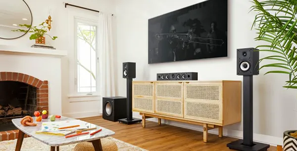 Bright living room with wireless speakers on a wooden console and a large flat screen TV, showcasing wireless speaker installation in Stuart, FL.